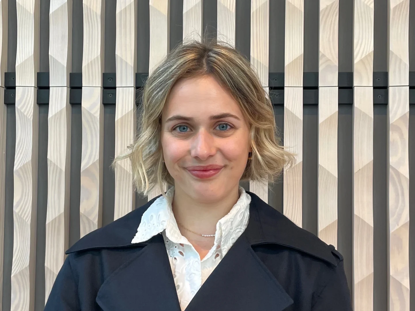 Eine Wissenschaftlerin und ein Wissenschaftler arbeiten hinter einer Glasfassade und mischen Chemikalien mit Großgeräten.